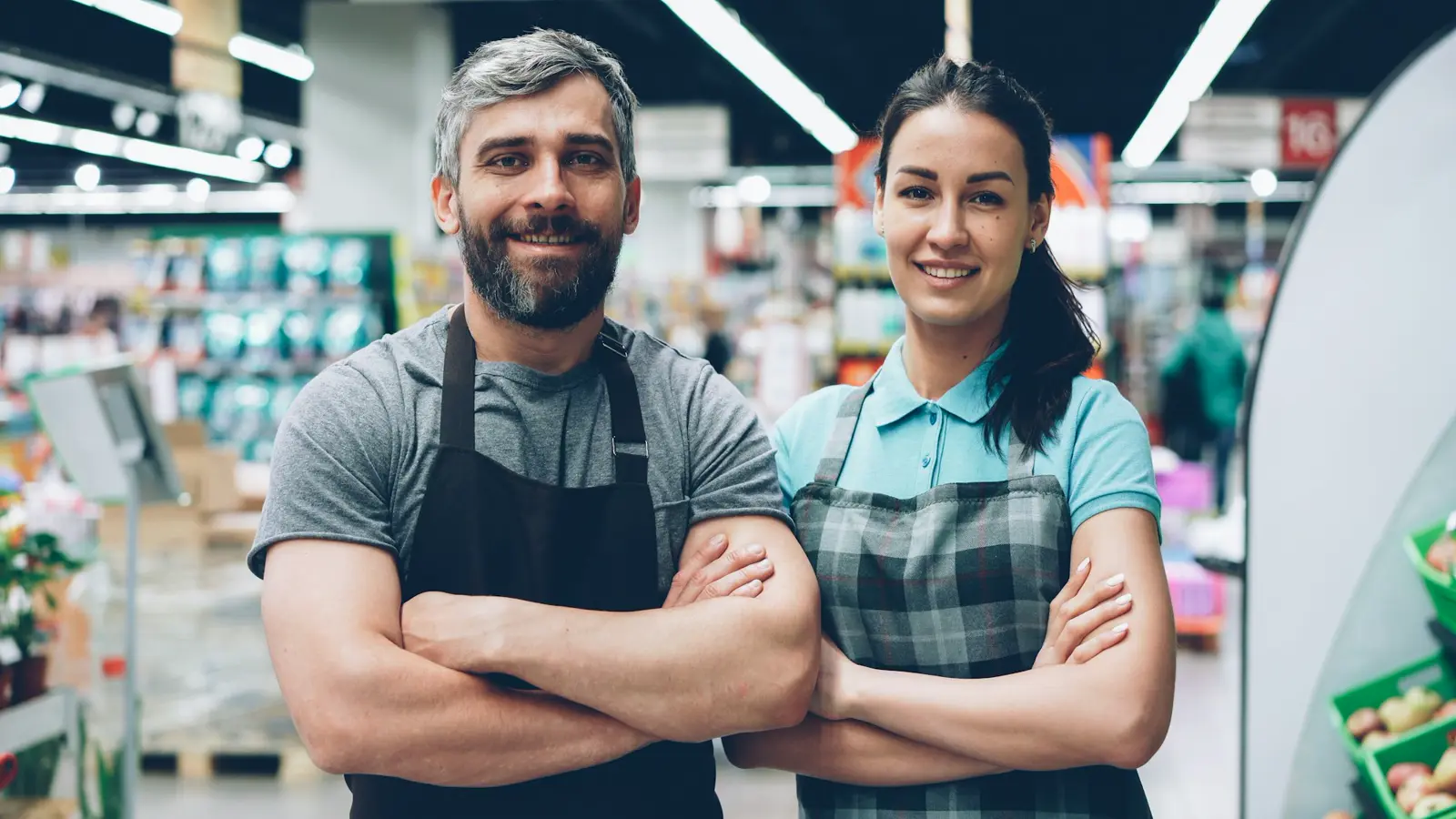 Markette çalışan, gülümseyen iki ekip arkadaşı